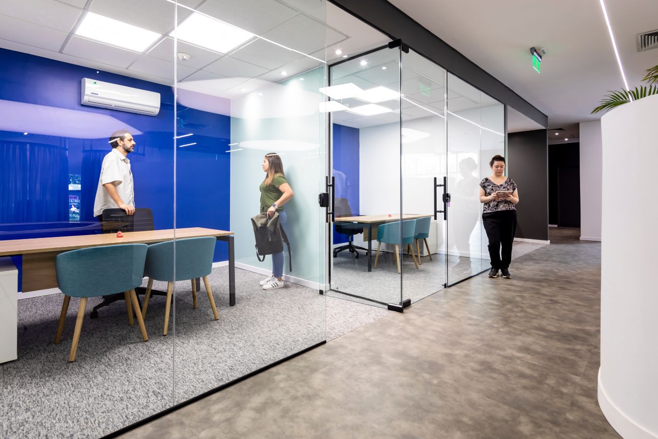 Aseguradora Yacyreta - Glass-fronted meeting rooms with bold blue accent walls - Contract Workplaces.jpg